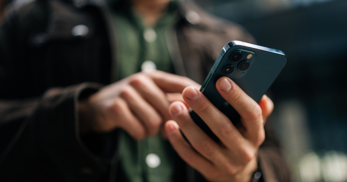 Persona que utiliza un teléfono inteligente para ponerse en contacto con un abogado especializado en divorcios con el fin de solicitar una consulta jurídica